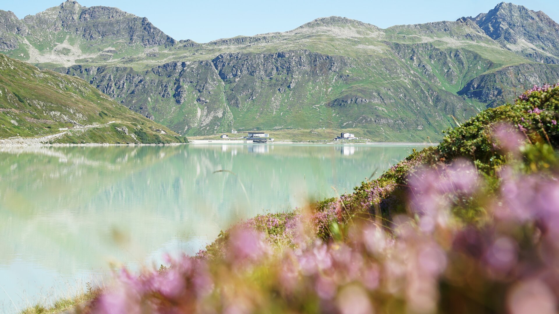 In einem See mit schimmernder Wasseroberfläche spiegelt sich das dahinter liegende Galtürer Bergmassiv.