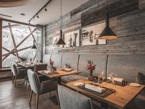 Ein elegantes Restaurant mit Holzwänden und gemütlichen Tischen. Die Atmosphäre ist warm und einladend, mit schönen Dekorationen auf den Tischen.