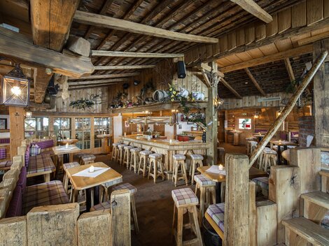 A cozy restaurant with wooden furniture and rustic ambiance. The warm atmosphere invites you to linger and dine.