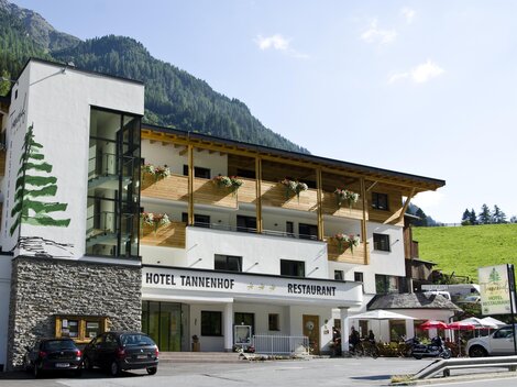 Ein gemütliches Hotel mit einem modernen und traditionellen Design. Es gibt eine Terrasse mit Tischen und Stühlen sowie einen schönen Blick auf die umliegenden Berge.