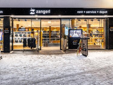 A store with sports and leisure clothing. The entrance area is welcoming and the surroundings are covered in snow.