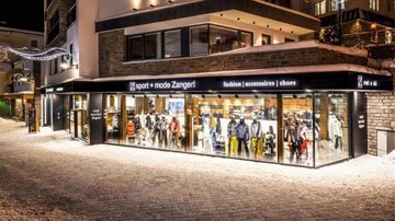 A modern fashion store with a large window front, showcasing a variety of clothing and accessories. The surroundings feel wintry and inviting.