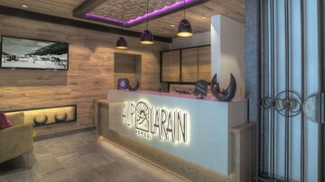 A modern hotel reception with wooden paneling and stylish lighting. The reception area is designed to be friendly and inviting.