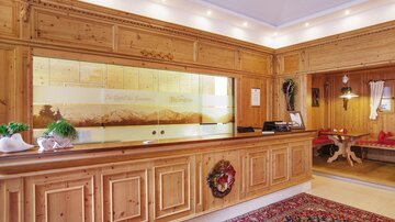 A reception area with wooden paneling and a warm ambiance. The furnishings are cozy and inviting.