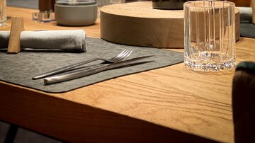 An elegant table in a restaurant with a bottle of red wine and glasses. The atmosphere is stylish and inviting.