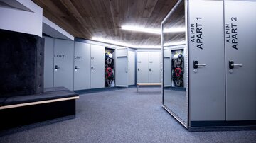 A modern entrance area with several cabinets and mirrors. The walls are bright, and the floor is covered with carpet.