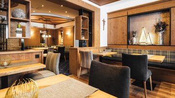 Ein gemütliches Restaurant mit Holzdekor und stilvollen Möbeln. Die warmen Farben schaffen eine einladende Atmosphäre.