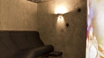 Ein entspannender Raum mit einem geschwungenen Sofa und sanfter Beleuchtung. Die Wände sind einfach gestaltet, und der Sternenhimmel verleiht eine gemütliche Atmosphäre.