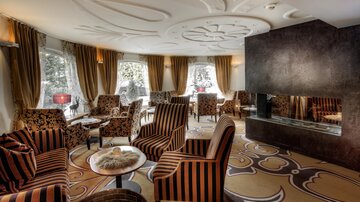 A stylish lounge with comfortable striped armchairs. Large windows provide plenty of daylight and a cozy atmosphere.