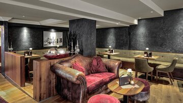A stylish restaurant with cozy seating and modern design. The warm lighting creates an inviting atmosphere.