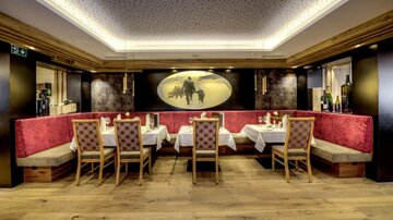 An elegant restaurant with cozy seating and stylish tablecloths. The warm colors and modern design create an inviting atmosphere.