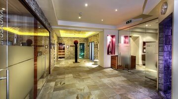 An elegant interior with stone walls and modern lighting. The space feels inviting and well-designed, perfect for relaxation.