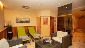 A relaxing wellness area with comfortable loungers and modern furniture. The warm colors create an inviting atmosphere.