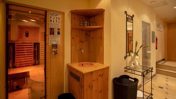 A relaxing wellness area with a sauna and a sink. The room has a cozy atmosphere and is well-lit.