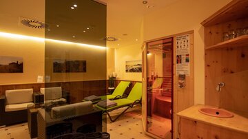 A relaxing wellness area with comfortable loungers and a sauna. The atmosphere is calm and inviting.