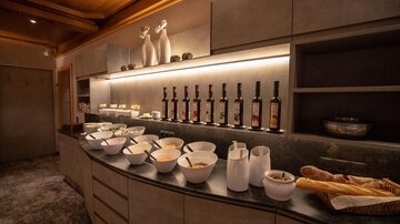 A modern kitchen unit with various bowls containing food. In the background are decorative bottles and vases.