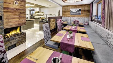 A modern restaurant with a cozy setting and an open fireplace. The tables are elegantly decorated and invite you to dine.