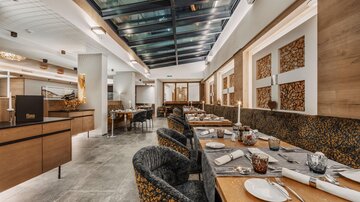 A modern restaurant with stylish tables and chairs. Large windows provide plenty of daylight and a welcoming atmosphere.