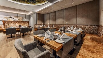 An elegant restaurant with modern tables and chairs. The laid tables are tastefully decorated and create an inviting atmosphere.