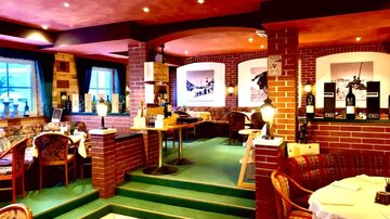 A cozy restaurant with a rustic atmosphere. Red brick walls and stylish tables invite you to linger.