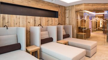 A modern wellness area with comfortable loungers. The wooden walls create a cozy atmosphere.