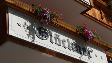 A wooden sign with the inscription "Bell ringer" and colorful flowers. The decoration gives the place an inviting atmosphere.