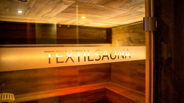 A textile sauna with warm lighting and wooden paneling. The atmosphere feels cozy and inviting.