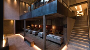 A modern wellness area with comfortable loungers and stylish wood design. Soft lighting creates a relaxing atmosphere.