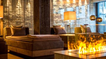 An elegant wellness area with comfortable loungers and warm light. The modern decor creates a relaxed atmosphere.