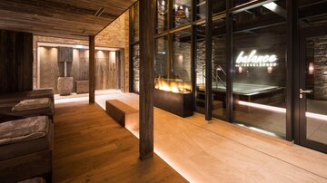 A modern wellness area with wooden paneling and pleasant lighting. In the background, the inscription "balance" can be seen.