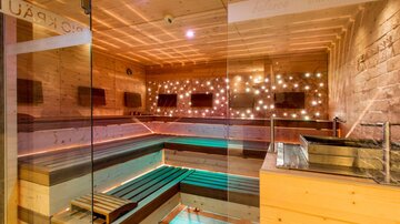 A modern spa with wood paneling and soft lights. The space is minimalist and inviting, perfect for relaxation.