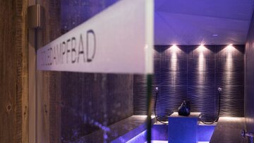 A modern steam room with soft lights and elegant tiles. The space radiates relaxation and tranquility.