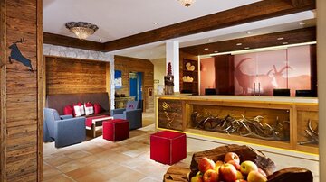 An inviting reception area with wooden details and cozy seating. A fruit basket and modern decor give the room a warm, friendly character.