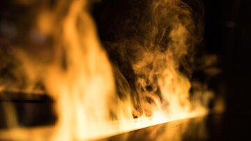 A fire with lively flames and smoke. The atmosphere is intense and dynamic.