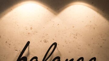 An elegant sign with the inscription "balance by ISCHGLERHOF". It radiates modernity and tranquility, illuminated by stylish lamps.