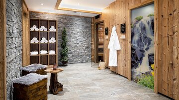 A modern wellness area with wood and stone elements. Towels and bathrobes are available to promote relaxation.