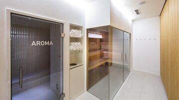 A modern wellness area with an aroma shower and a glass sauna.  
Well-maintained towels are ready, and the walls are in soft, natural colors. | © Rössle