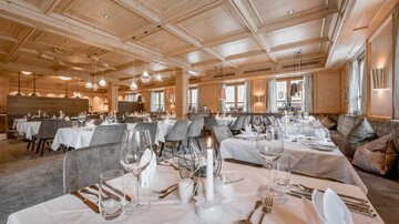 An elegant restaurant with stylish tables and modern furniture. Soft lighting creates an inviting atmosphere.