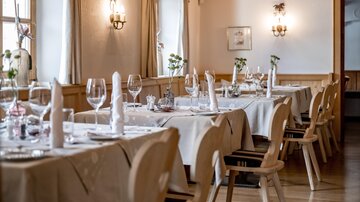 An elegantly decorated restaurant area with beautifully set tables. Soft light and an inviting atmosphere create a cozy environment. | © Rössle