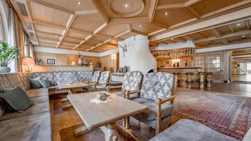 A cozy lounge with a wooden ceiling and comfortable furniture. The warm atmosphere invites you to relax.