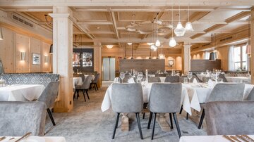 An elegant restaurant with light wood elements and stylish table settings. The atmosphere is inviting and modern.