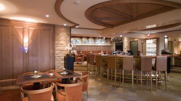 An elegant restaurant with wood paneling and a cozy bar. The atmosphere is inviting and modern.