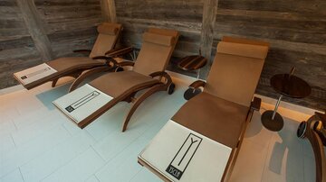 Relaxing loungers in a modern room with wood paneling. The comfortable furniture provides an inviting atmosphere for relaxation.