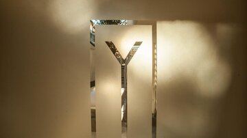 A minimalist sign with the letter "Y". The light gently refracts through the smooth surface.